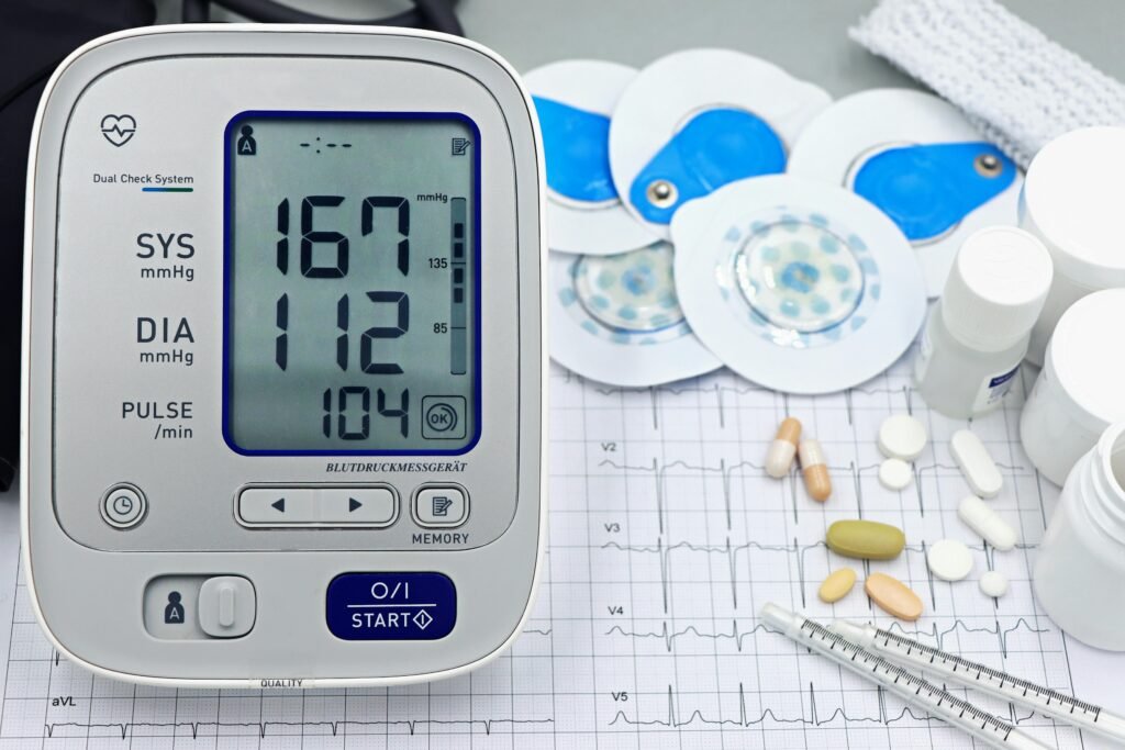 A close-up shot of medical equipment including blood pressure monitor and pills on an ECG graph.