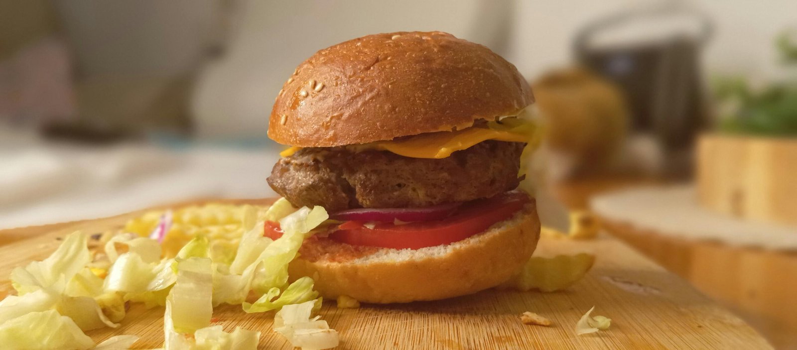 Close-up of a cheeseburger with fresh toppings on a wooden board, showcasing culinary appeal.
