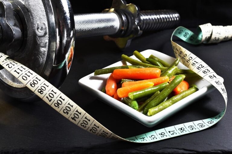 Dumbbells and fresh vegetables illustrating satiety and strength strategies during early weight loss hunger spikes